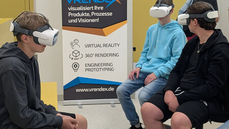 Drei jungen haben VR-Brillen auf.