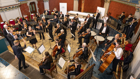 Mehrere Personen musizieren im Altarraum einer Kirche.