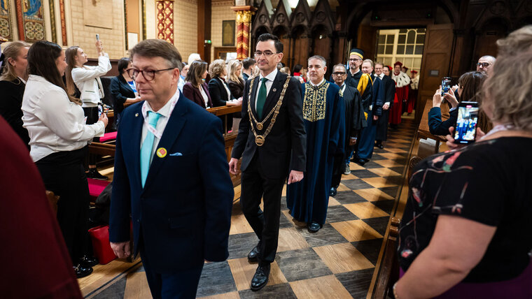 Mehrere Personen laufen in eine Kirche hinein.