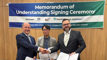 Drei Männer stehen nebeneinander und halten Dokumente in den Händen.