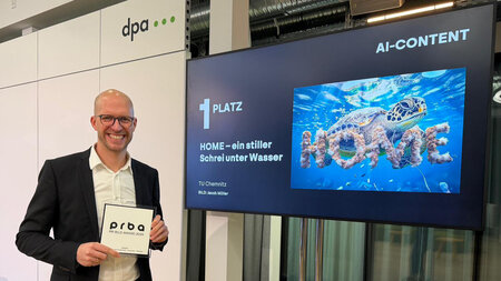 Ein Mann hält einen Preis in den Händen.