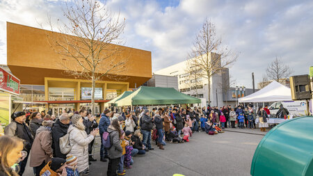 Viele Personen stehen vor einem Gebäude.