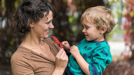 Eine Frau trägt ein Kind auf dem Arm.