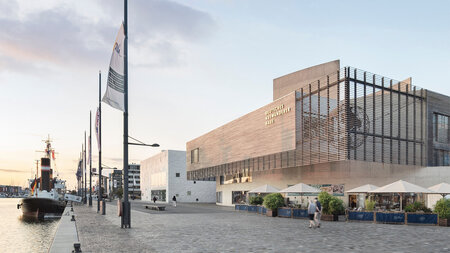 Blick auf ein schiff, das neben einem Gebäude ankert. 