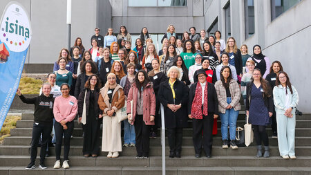 Frauen stehen in mehreren Reihen auf einer Treppe nebeneinander