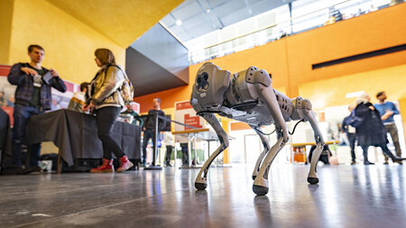 Ein Roboterhund läuft durch ein Foyer.