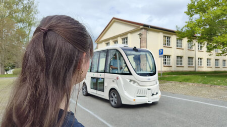 Eine Frau steht neben einem Fahrzeug.