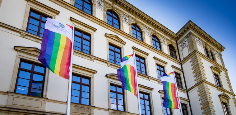 Hauptgebäude Straße der Nationen im Hintergrund und den Regenbogenflagge der TU Chemnitz im Vordergrund