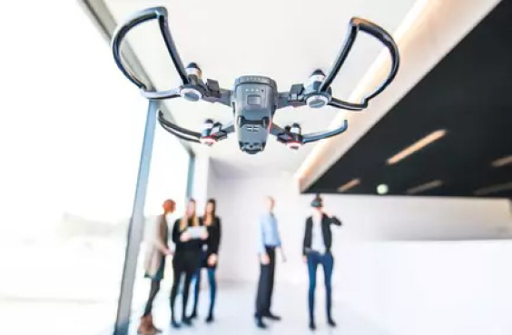Eine Drohne fliegt vor einer kleinen Gruppe von Menschen