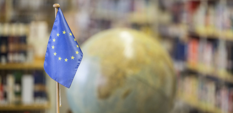 Eine Europa-Fahne vor einem Globus.