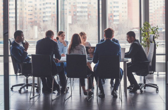 Eine dienstliche Besprechung elegant gekleideter Personen.