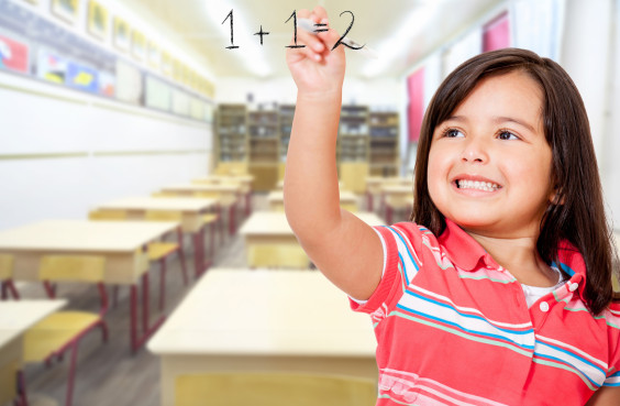 Ein kleines Mädchen schreibt 1+1=2 an eine Glasscheibe.