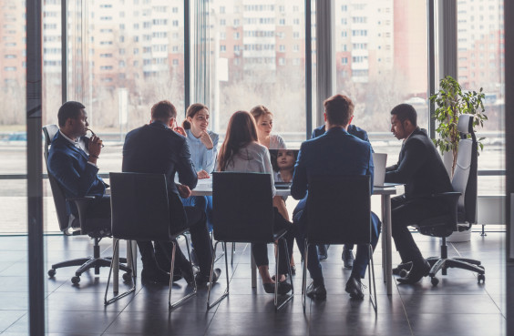 Eine dienstliche Besprechung elegant gekleideter Personen.