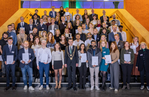 Stipendiatinnen und Stipendiaten versammelten sich gemeinsam mit ihren Fördernden zum Gruppenfoto auf der Treppe im Foyer des Hörsaal- und Seminargebäudes