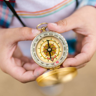 A person is holding a historical compass in their hands. 