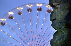 Chemnitzer Marx-Kopf blickt auf beleuchtetes Riesenrad