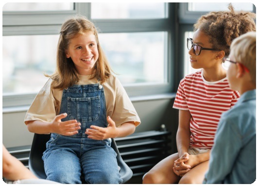 lachendes M�dchen erkl�rt anderen Kindern etwas