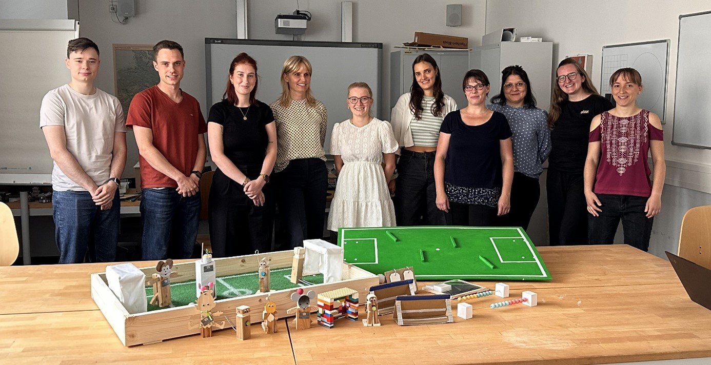 Studenten stehen hinter dem selbstgebauten TippKick Spiel